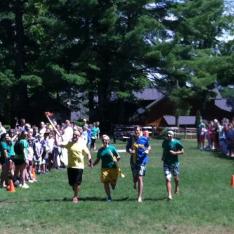 Campers cheer as the Olympic torch passes by